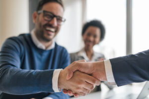 Happy business professionals doing handshake at successful